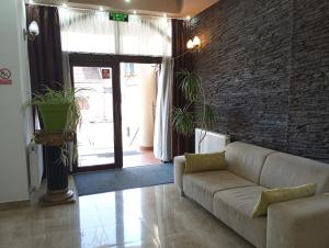 sala de estar con sofá y pared de ladrillo en RHC Royal Hotel en Oradea