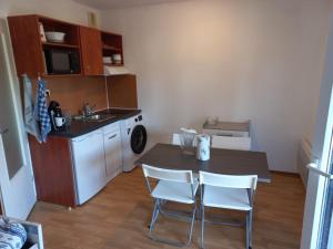 a kitchen with a table and chairs and a sink at Appartement Le Verdon sur mer in Le Verdon-sur-Mer +6 photos