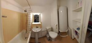 a bathroom with a toilet and a sink and a tub at Appartement Le Verdon sur mer in Le Verdon-sur-Mer