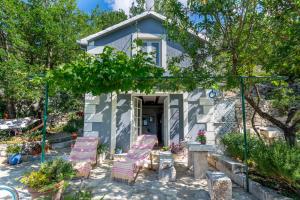 a group of chairs sitting in front of a house at Karla planinska kuća in Baška Voda