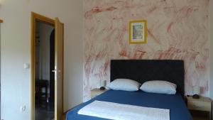 1 dormitorio con cama azul y pared roja en Apartments Luna, en Sukošan