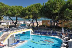 a swimming pool at a resort with a beach at Hotel Miramare in Lignano Sabbiadoro