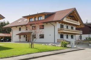 a house with a brown roof at FENJOY Ferienapartments am Chiemsee mit Bergblick in Bernau am Chiemsee