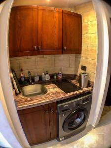 uma cozinha com um lavatório e uma máquina de lavar roupa em Premier Beachfront Studio- Foreign Nationals Only em Hurghada