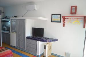eine Küche mit einem Schreibtisch und einem TV in der Unterkunft Studio Tishka in Oualidia