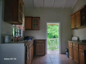 una cucina con armadi in legno e una porta aperta di East Caribbean Lodging a Gros Islet Altre 19 foto