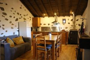 a kitchen and dining room with a table and a couch at Casa dos Trilhos in Lousã