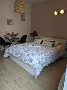 a bedroom with a bed and a table with chairs at Chez Cerise in Tournay