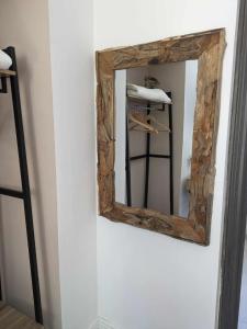 a mirror with a wooden frame on a wall at Chez Cerise in Tournay