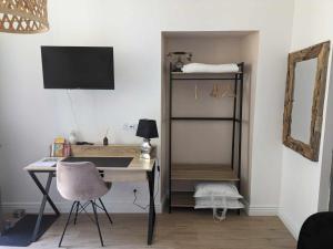 a desk with a chair and a computer in a room at Chez Cerise in Tournay