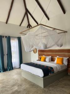 Tanzania Safari Lodge في أروشا: غرفة نوم مع سرير مع شبك معلق من السقف