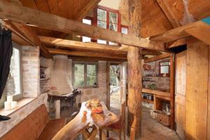 a log cabin kitchen with a table and a fireplace at Margaritis's Treehouse in Paramonas