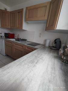 a kitchen with wooden cabinets and a counter top at Appartement à proximité de disney de val d europe in Montévrain