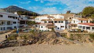 un grupo de casas en un pueblo en una colina en Blue fisherman house 2 By homevillas360, en Cala de Sant Vicent