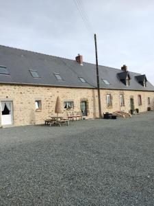 a building with a table and chairs in front of it at Chambre d'hôtes l'orchidée in Voutré