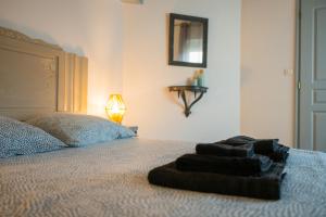 a bed with a pile of towels on it at Chez la fille de l éclusier in Castelnaudary