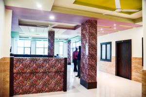a man standing in a lobby with a wall of curtains at Hotel Global Inn in Udaipur