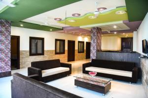 a living room with two couches and a table at Hotel Global Inn in Udaipur