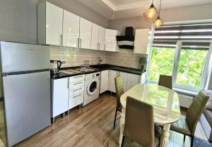 a kitchen with a white refrigerator and a table with chairs at Garsoniera Soroca in Soroca