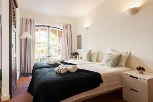 sypialnia z 2 łóżkami i oknem w obiekcie Old Village & Prestige w mieście Vilamoura
