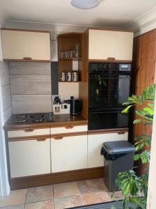 a kitchen with white cabinets and a black appliance at Kings Lynn 1 in Kings Lynn