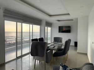 a dining room with a table and chairs and the ocean at Dept en Playas Sol Arena Mar y Piscina in Playas