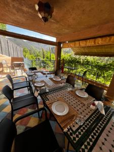 comedor con mesa y sillas en el patio en Jnane Ayam Atlas, en Ourika