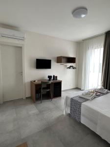 Dormitorio con cama, escritorio y TV en Calafato Guest House en Favignana