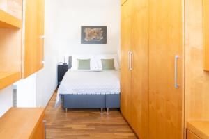 ein kleines Schlafzimmer mit einem Bett und Holzschränken in der Unterkunft River View Apartment in Prag