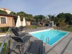 een zwembad met 2 stoelen en een tafel bij Borgo Barone in Mascali