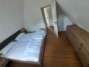 a bed in a room with a wooden floor at Häuschen am See in Cappel