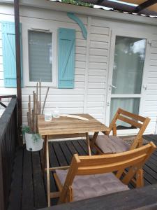 un tavolo in legno e 2 sedie su una terrazza di Slow M'Ocean Villa a Pataias