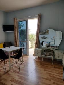 een woonkamer met een tafel, een stoel en een spiegel bij Apartments Vista Mar in Orikum +26 foto's