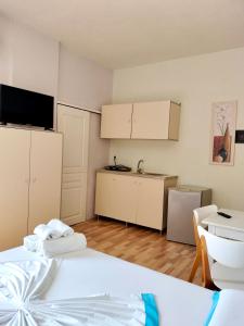 een kamer met een bed en een keuken met een tv bij Apartments Vista Mar in Orikum