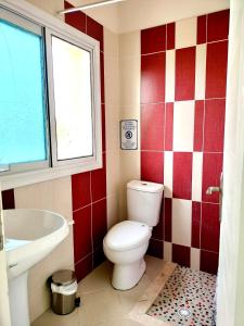 a bathroom with a toilet and a sink and a window at Apartments Vista Mar in Orikum +21 photos