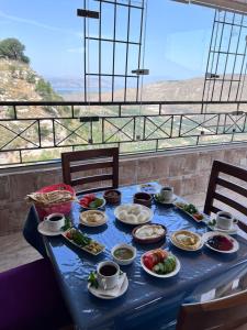 niebieski stół z talerzami jedzenia w obiekcie منتجع وفندق جدارا Jadara Resort & Hotel w mieście Um Qeis