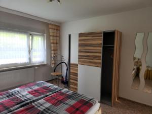 a bedroom with a bed and a refrigerator and a window at Ferienwohnung Lux in Markische Heide