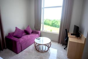 uma sala de estar com um sofá roxo e uma janela em Nulife Resort em Jamnagar