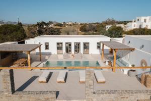 a patio with a swimming pool and a house at Noble Pearl Villas Paros in Santa Maria