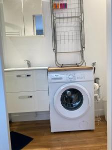una lavatrice in una cucina con specchio di Logement T2 neuf-évasion en Corrèze a Ligneyrac