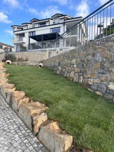 ein Haus mit einer Steinmauer und etwas Gras in der Unterkunft Villa la Matta in Sanremo