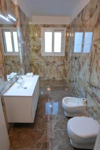 ein Badezimmer mit Waschbecken und Toilette in der Unterkunft Era Palace Apartments in Vlorë