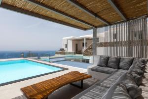 sala de estar con sofá y piscina en Villa Cataleya 3 PRIVATE POOL, en Fanari
