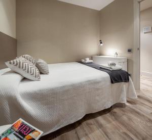 バルセロナにあるハビタット アパルトメンツ パセオ デ グラシアのウッドフロアのベッドルーム1室(大きな白いベッド1台付)