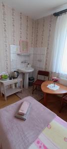 a bathroom with a bed and a sink and a table at Pokoje Gucio in Łeba +41 photos