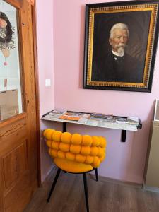 une peinture d'un homme sur une table avec une chaise jaune dans l'établissement Vila Alice Bled - Adults only, à Bled