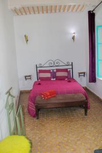 a bedroom with a large bed with red pillows at Riad Darko in Essaouira