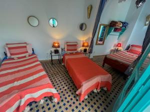 um quarto com 2 camas e um espelho em Riad Darko em Essaouira