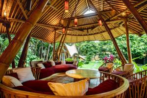 a large outdoor room with couches and a table at Cacao House Eco-Luxury Family Home by IBUKU near Green School Bali in Bringkit