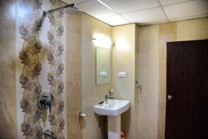 a bathroom with a sink and a mirror at Hotel Global Inn in Udaipur +16 photos